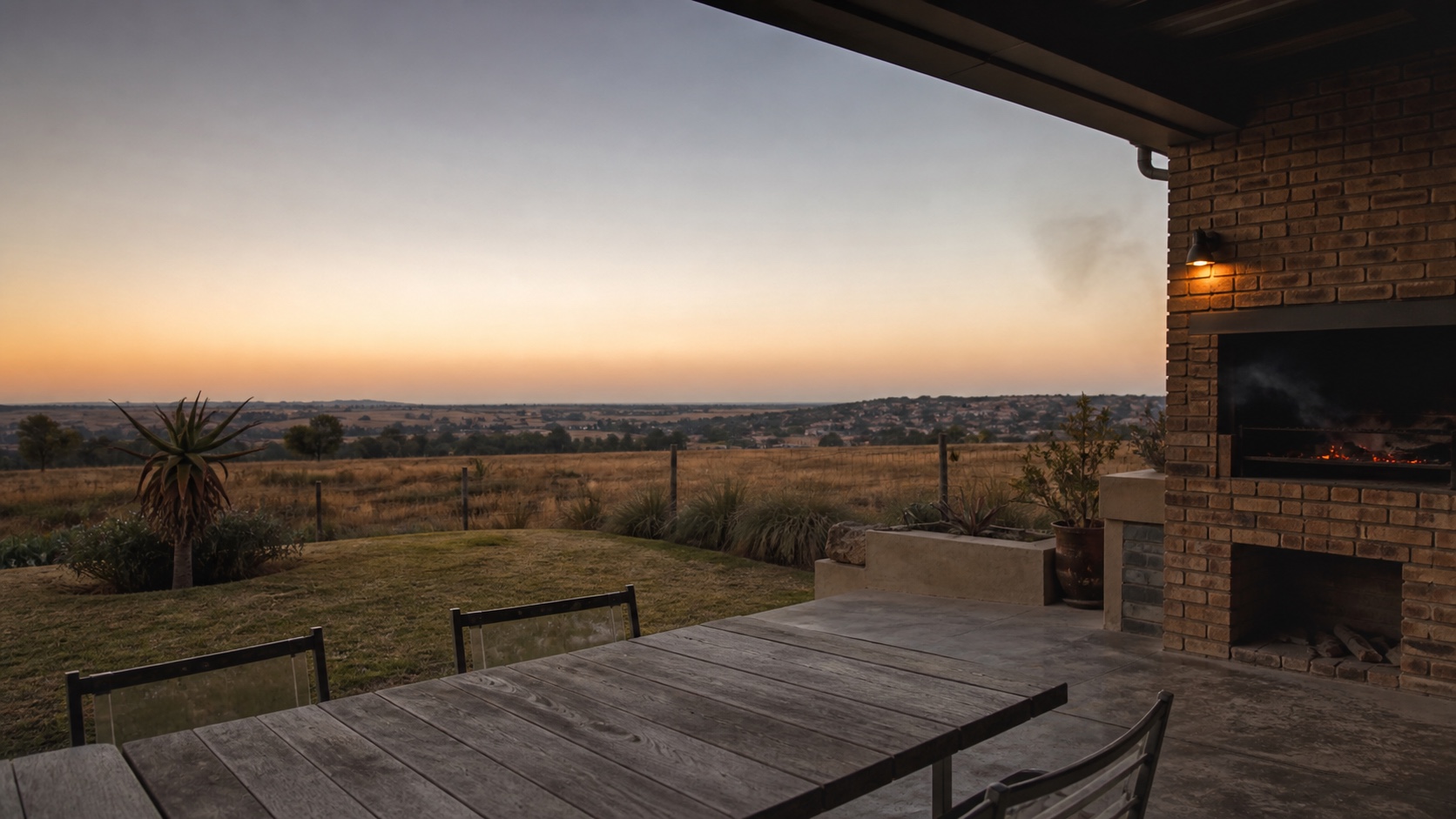 An open South African braai patio overlooking the veld at sunset